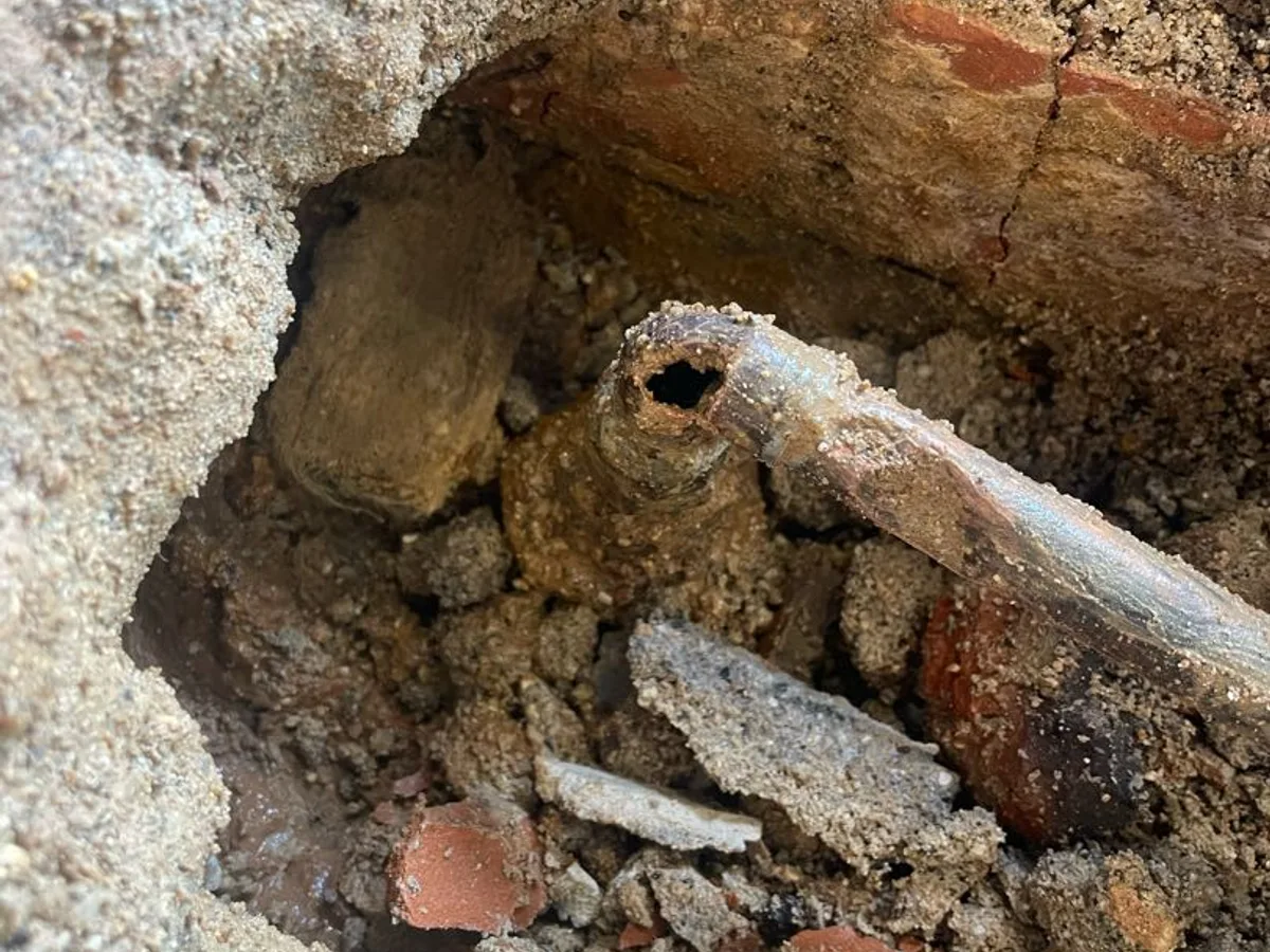 fault exposed at failed copper pipe connection beneath kitchen floor slab