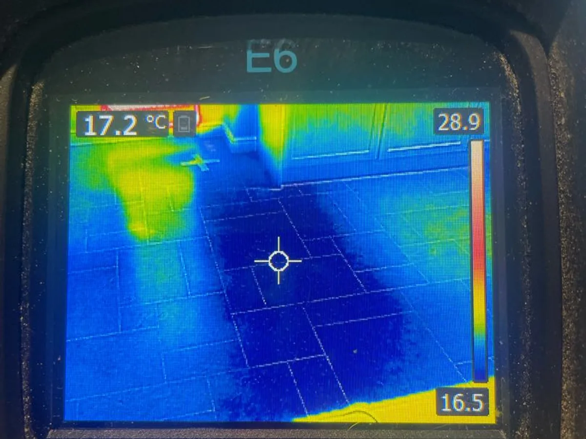 thermal imaging camera screen showing cold saturation zone across tiled floor during leak detection